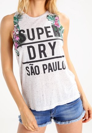 Top grigio senza maniche con stampa floreale tropicale e scritta "SUPER DRY SÃO PAULO", indossato con pantaloncini di jeans blu.