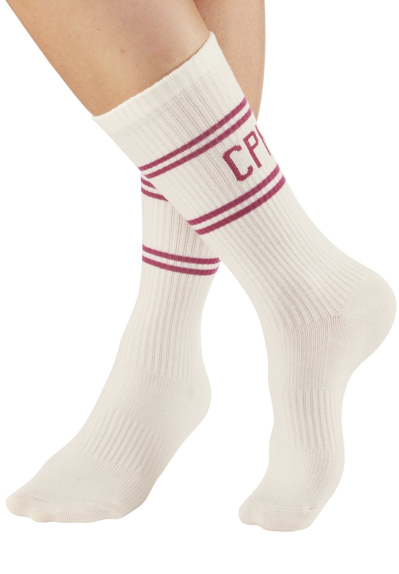 Calcetines blancos de canalé con rayas rosas y las letras "CP" impresas en la parte superior. La textura parece suave y elástica.