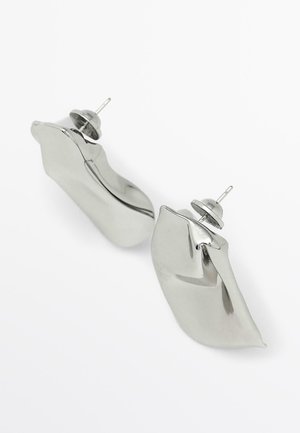 Zilverkleurige metalen oorbellen met een gebogen ontwerp, voorzien van een gepolijste afwerking en een sluiting met pen en achterkant. Het oppervlak is glad en reflecterend.