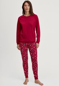 Rode lounge set met een lange mouwen crew neck top en geblokte pyjamabroek met winterthema ontwerpen in wit en marineblauw.