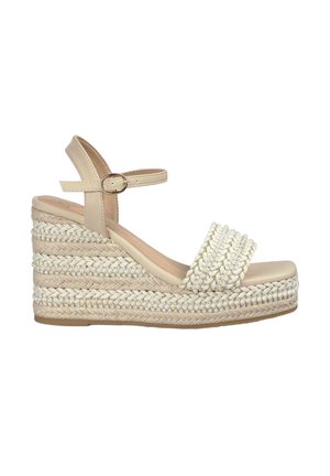 Beige wedge sandal featuring braided jute and textile accents, a wide upper strap, ankle strap with buckle, and textured sole.
