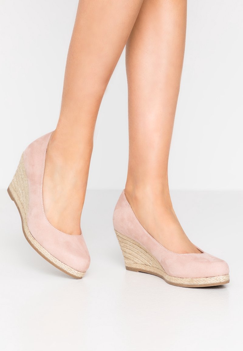 Lichte roze suedine wedge schoenen met een ronde neus en een stroachtig textuur op de wedge hak, met een gladde bovenkant en een zachte afwerking.