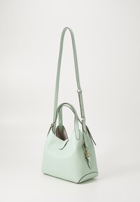 Mint green leather handbag with two handles and an adjustable strap. Features a structured shape and subtle texture with curved edges.