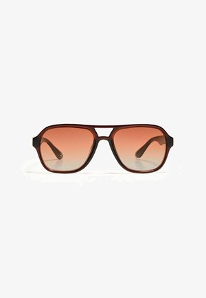 Lunettes de soleil marron avec une monture rectangulaire et des verres dégradés orange. La monture a une finition mate, avec un détail de découpe central.