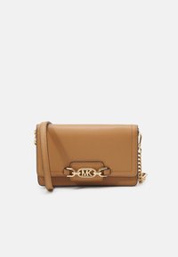 Sac bandoulière en cuir tan avec quincaillerie dorée et une bandoulière en chaîne. Comprend un fermoir avec un logo gravé et un design rectangulaire structuré.