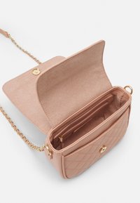 Sac à bandoulière en simili cuir rose matelassé avec une bandoulière en chaîne dorée, fermeture magnétique et une poche zippée intérieure.