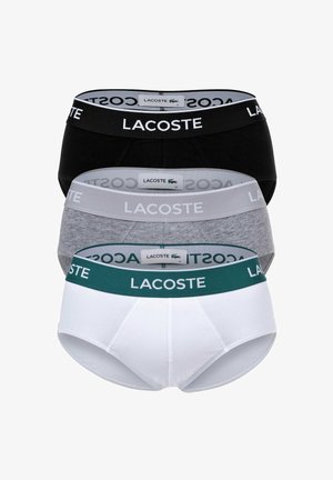 Set di slip da uomo Lacoste disponibile in tre colori: nero, grigio e bianco. Ognuno presenta un elastico in vita marchiato e tessuto in cotone per il massimo comfort.