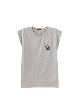 T-shirt gris à manches courtes avec un col rond et des épaules à panneaux. Présente un motif graphique noir sur la partie gauche de la poitrine.