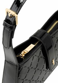 Błyszcząca czarna torebka pikowana z złotym zamkiem, złotą klamrą na pasku oraz złotym logo na przednim klapie.