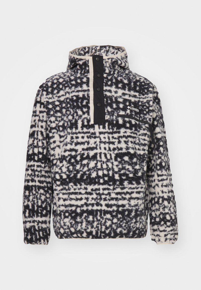 Polarowy golf w czarno-białym geometrycznym wzorze, z guzikami z przodu i kapturem. Posiada kieszeń na piersi z detalem logo.