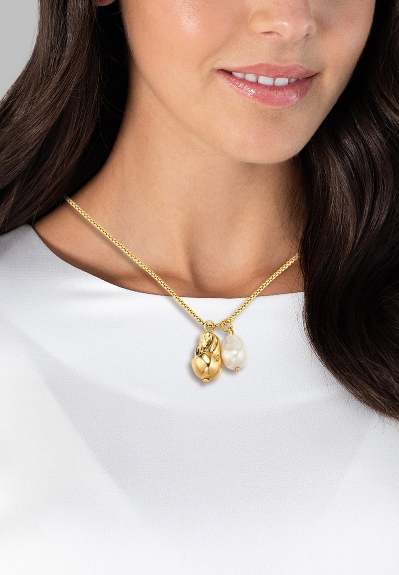 Collana d'oro con due pendenti: una goccia d'oro e una perla bianca. La catena è delicata e presenta una superficie decorata.