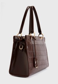 Braune Handtasche aus Kunstleder mit Krokodilprägung, goldfarbener Hardware, zwei Griffen und rechteckiger Form. Mit einem Detail an der Seitentags.
