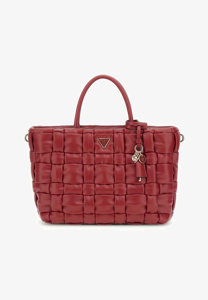 Sac à main en cuir tressé rouge avec deux poignées, emblème de logo et charms décoratifs. Forme rectangulaire avec une finition texturée.