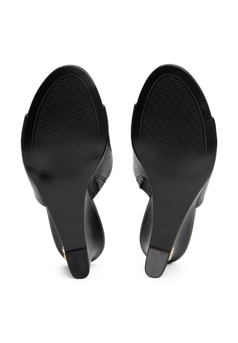 Schwarze Lederhighheels mit glatter Textur, abgerundeten Zehen und einer strukturierten Gummisohle. Mit einer leichten Kurve an der Ferse.