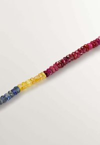 Cuentas de piedras preciosas multicolores en una disposición graduada, con tonalidades azules, amarillas y rosas, con una textura facetada y formas irregulares.