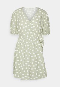 Grön omlottklänning med vita prickar, korta puffärmar, V-ringning, knytning i midjan och flowy kjol. Strukturerad tyg.