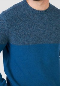 Maglione blu lavorato a maglia con scollo rotondo, sezione superiore grigio-blu strutturata e sezione inferiore di un blu più scuro uniforme.