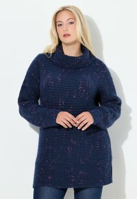 Wiadro sweter w ciemnym granacie z wysokim kołnierzem, z różowymi akcentami w kropeczki, długimi rękawami oraz luźnym krojem z rozcięciami po bokach.