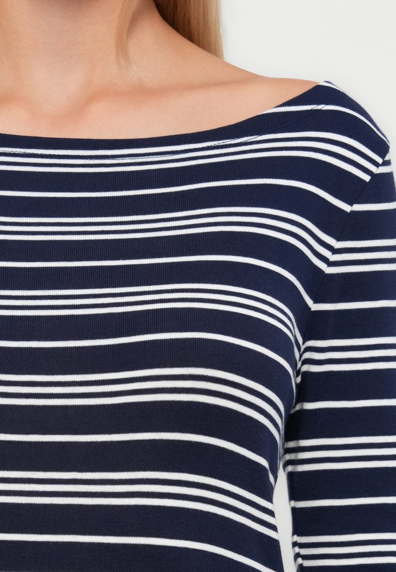 Marineblaues Langarmoberteil mit weißen horizontalen Streifen, featuring einen weiten Bootsausschnitt und glattem, leicht strukturiertem Stoff.