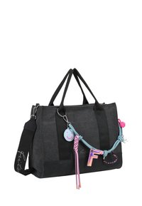 Sac à main en tissu noir avec deux poignées courtes et une bandoulière réglable. Présente des charms colorés, y compris un visage souriant et la lettre "F".