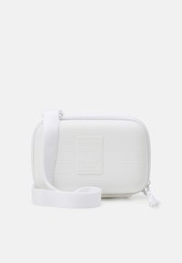 White rectangular bag with a textured surface, adjustable fabric strap, and embossed Adidas logo on the front. Zippered closure.