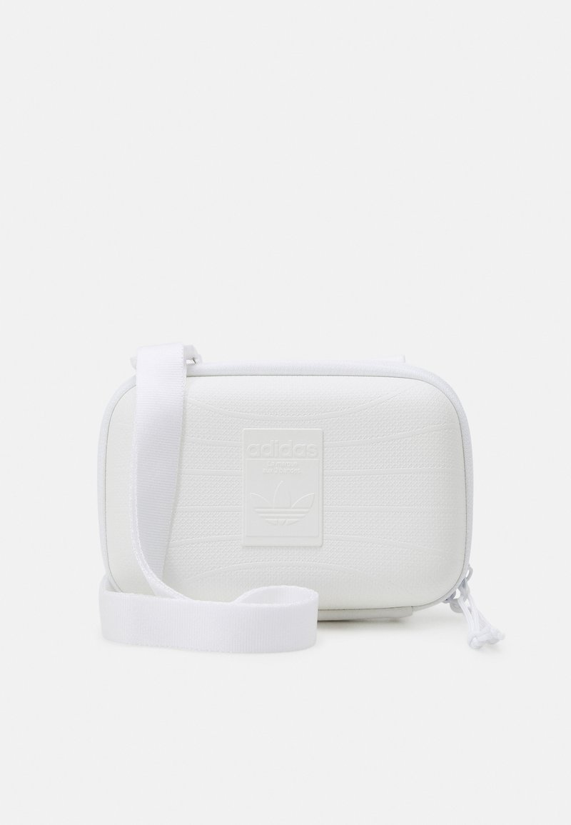 White rectangular bag with a textured surface, adjustable fabric strap, and embossed Adidas logo on the front. Zippered closure.