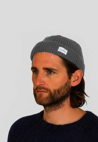 Gray ribbed beanie hat made of knitted fabric with a folded cuff, featuring a small white label on the front.
