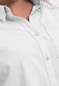 Hvid skjorte med knapper lavet af struktureret stof, med krave, knapper foran og en lomme på venstre side.