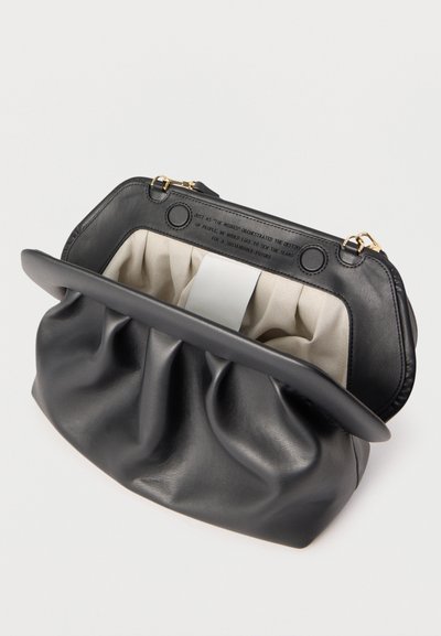 Must nahast klamberrahakott pehmete kortsudega, beežist kangast sisemus ja kuldse tooni metallosad ühtlase hele tausta peal.