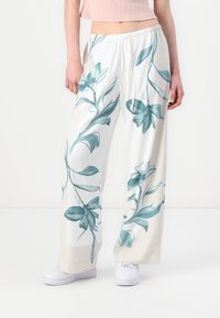 Wide-leg pants in lightweight fabric, featuring a floral print in teal on a white background. Elastic waistband with a drawstring detail.