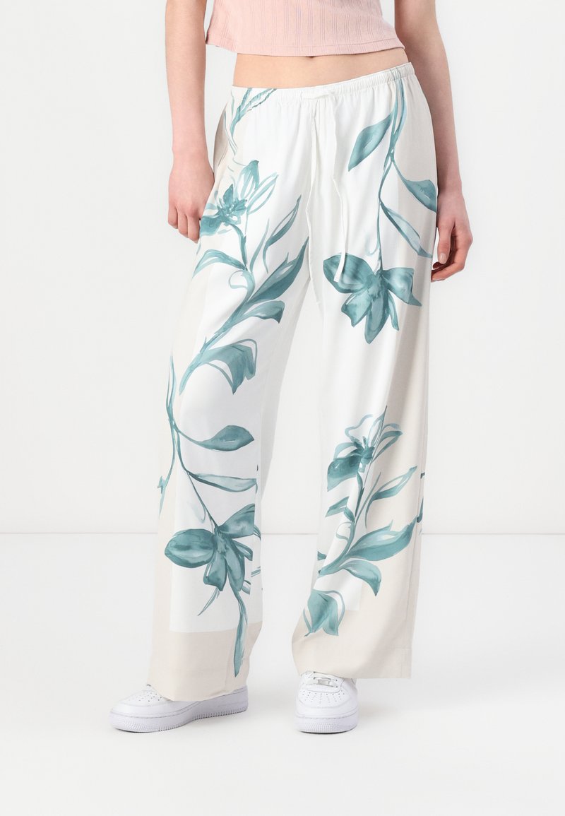 Wide-leg pants in lightweight fabric, featuring a floral print in teal on a white background. Elastic waistband with a drawstring detail.