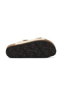 Sandalo beige con soletta in sughero e suola spessa in gomma nera. Presenta due cinturini regolabili e una suola texturizzata per una migliore aderenza.