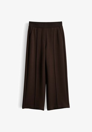 Dunkelbraune, weit geschnittene Hose mit elastischem Bund und vorderen Nahtdetails, auf weißem Hintergrund dargestellt.