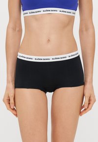 Μαύρες σλιπ σε στυλ μποξέρ από βαμβάκι με λευκή ελαστική μέση που φέρει το λογότυπο "BJÖRN BORG". Ο σχεδιασμός είναι χωρίς ραφές με άνετη εφαρμογή.