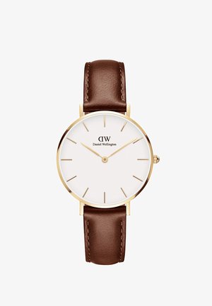 Ümar kell, millel on kuldtooni korpus, valge nägu, kuldsed tunni indikaatorid ja pruun nahkrihm. Omab kaubamärgi logo "Daniel Wellington."