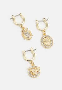 Brincos em tom dourado em forma de argola, adornados com pingentes de coruja, leão e borboleta, cada um destacado com strass transparentes para um brilho extra.