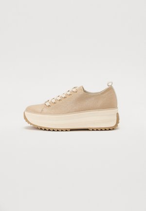 Beige Low-Top-Sneaker mit dicker weißer Plattformsohle, cremfarbigen Schnürsenkeln, metallischen Ösen, strukturiertem Stoff und einer Schlaufe an der Ferse.