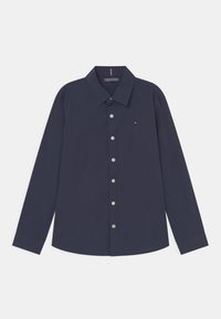 Chemise à manches longues bleu marine avec col, boutons blancs et petit logo brodé sur la poitrine gauche.