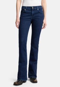 Donkerblauwe uitlopende jeans met een gladde textuur, hoge taille, voorzakken, gouden knoopaccenten en contrasterende stiksels langs de naden.