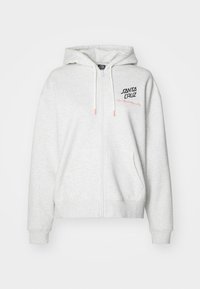 Haut de sweatshirt zippé gris clair en tissu doux. Présente une capuche avec cordon de serrage, des poches latérales et "SANTA CRUZ Skateboards" brodé sur la poitrine.