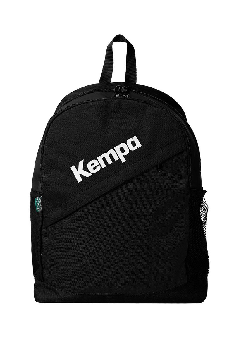 Mochila negra con un acabado de tela suave, que presenta un gran logo blanco de "Kempa", un asa superior y un bolsillo de malla lateral.
