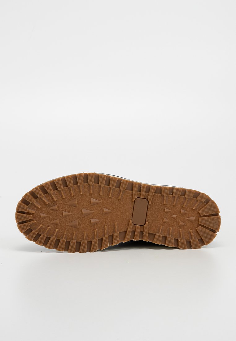 Semelle en caoutchouc brun avec un motif de bande de roulement texturé, dotée de crampons multidirectionnels pour l'adhérence et d'une section de support central.