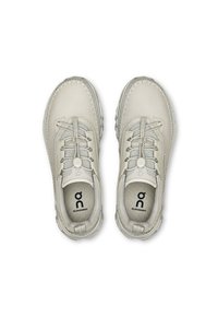 Ljust grå sneakers med övre i slät läder, textilaccenter, elastiska skosnören och en vadderad innersula med en logo. Rund tådesign.