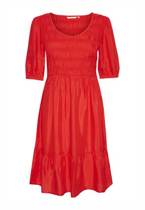Punane lühikeste varrukatega kleit, millel on smockitud bodi ja kihiline, laienev äär. Valmistatud siledast kangast, millel on läikiv viimistlus.