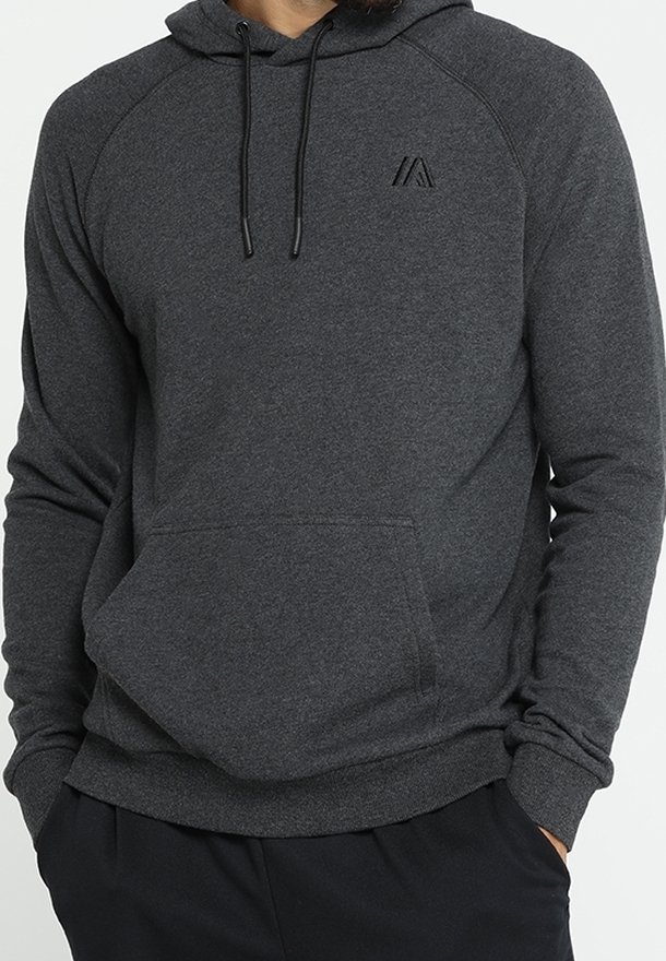 Sweat à capuche gris foncé avec poche kangourou à l'avant et cordons noirs, porté avec un pantalon noir.