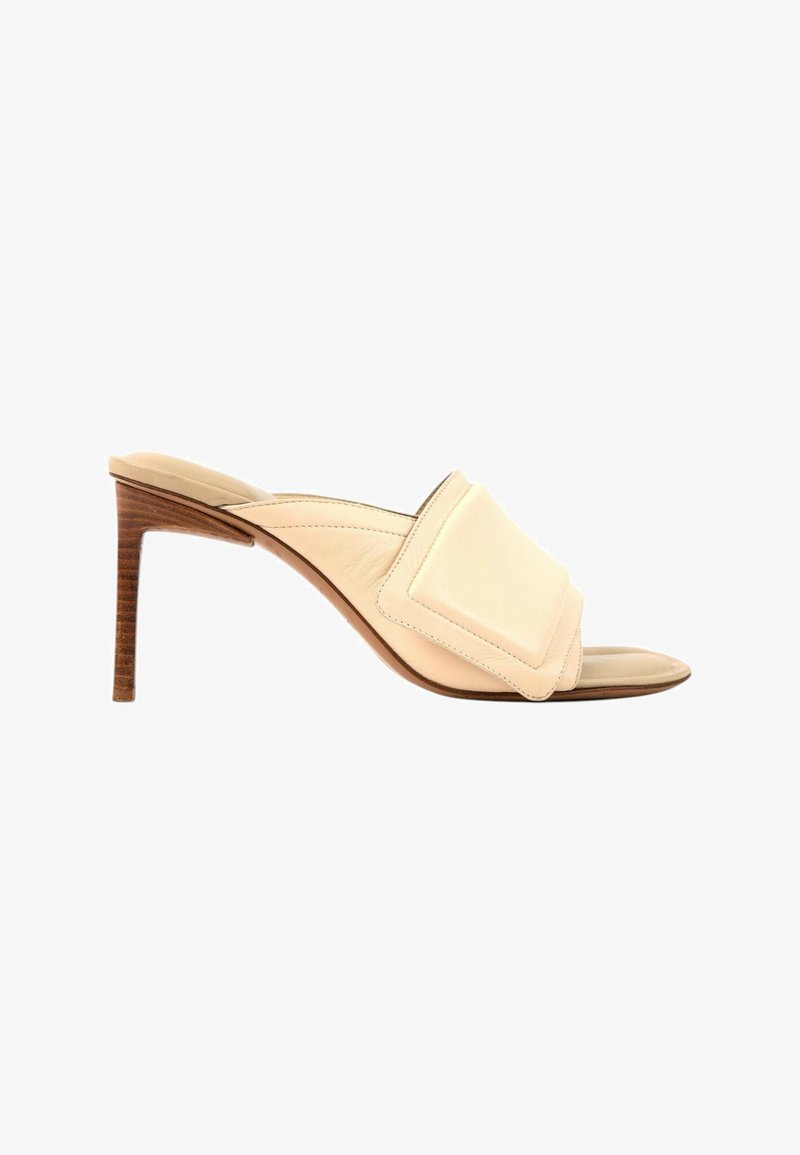 Mule beige à bout ouvert avec une large bride rembourrée et un talon stiletto en bois de hauteur moyenne.