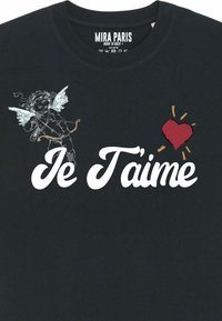 T-shirt en coton noir avec "Je T'aime" en police cursive blanche, accompagné d'une illustration de chérubin et d'un design de cœur rouge. Texture douce, coupe décontractée.