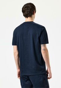 Marineblå kortærmet t-shirt lavet af bomuld, med rund halsudskæring og en glat tekstur, med syninger og en afslappet pasform.