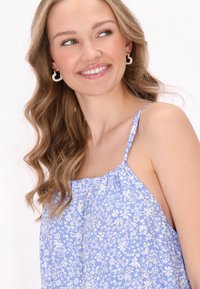 Rochie fără mâneci, cu print floral albastru, guler strâns și bretele subțiri. Prezintă modele de flori albe pe un fundal bleu deschis.