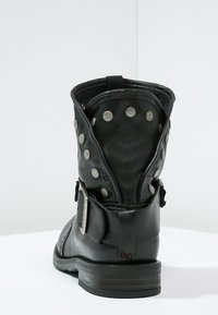 Czarne skórzane botki za kostkę z srebrnymi ćwiekami, klamrą oraz niskim, warstwowym obcasem, o fakturowanej powierzchni i zaokrąglonym nosku.